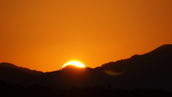 稜線に沈む夕陽の風景写真　高画質の壁紙